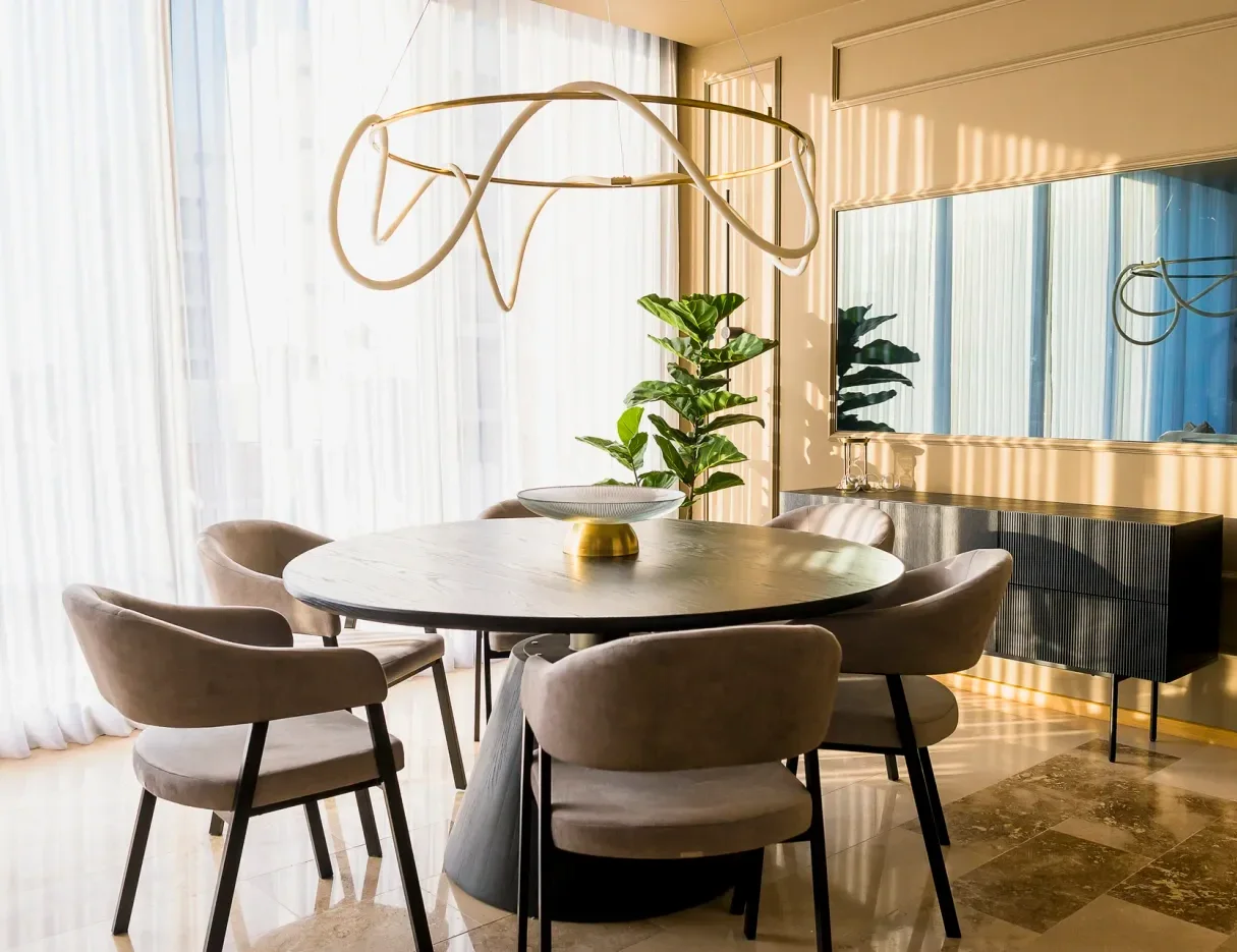 Comedor con luz de sol entrando por las persianas, de un proyecto de Bichu Arquitectura